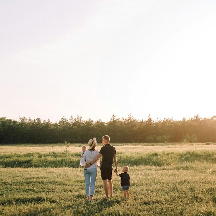 man and woman walking on green grass field during daytime